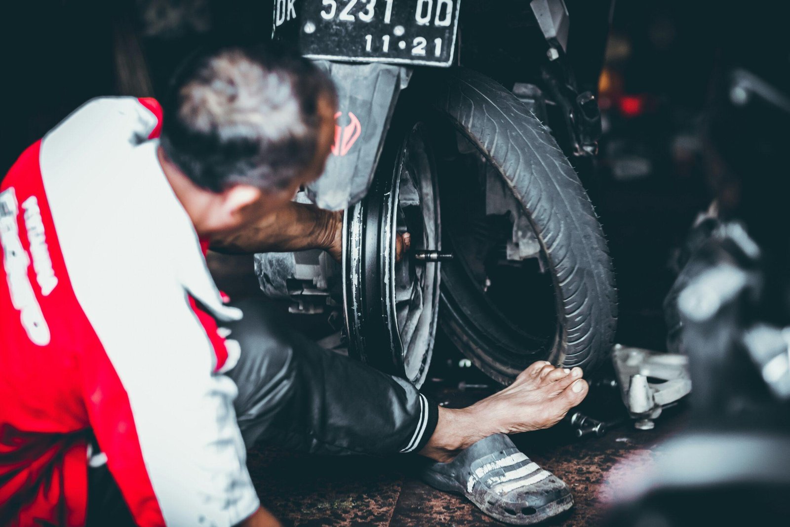 Mechanic assisting a stranded driver by changing a tire