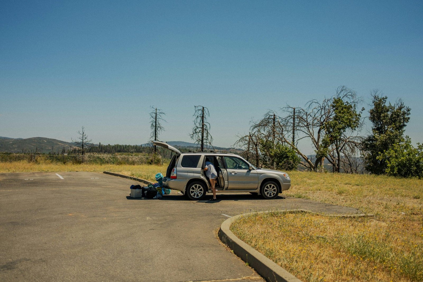 Car with an empty gas tank parked on the shoulder of a highway