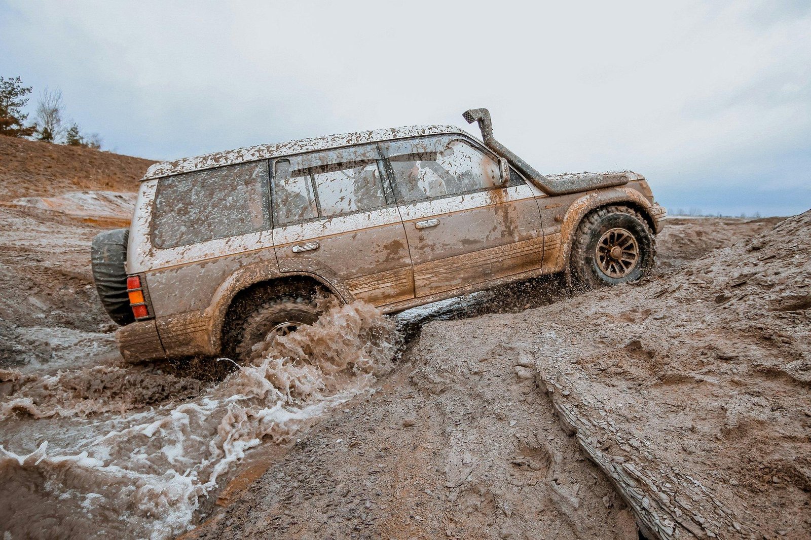 A car stranded in snowy conditions requiring off-road recovery